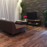 ブラックウォルナット無垢フローリングとレンガ調壁が調和するリビング