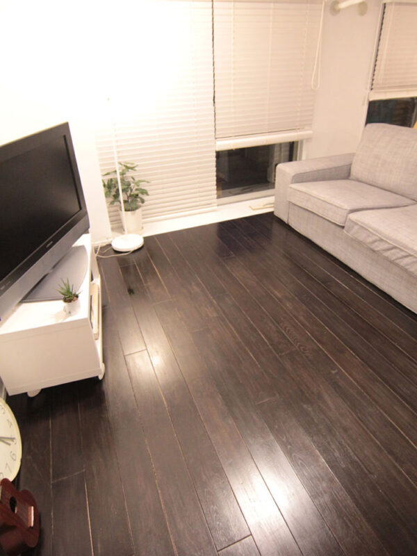 ブラック塗装を施したオーク無垢フローリングを採用したリノベーション済みリビング