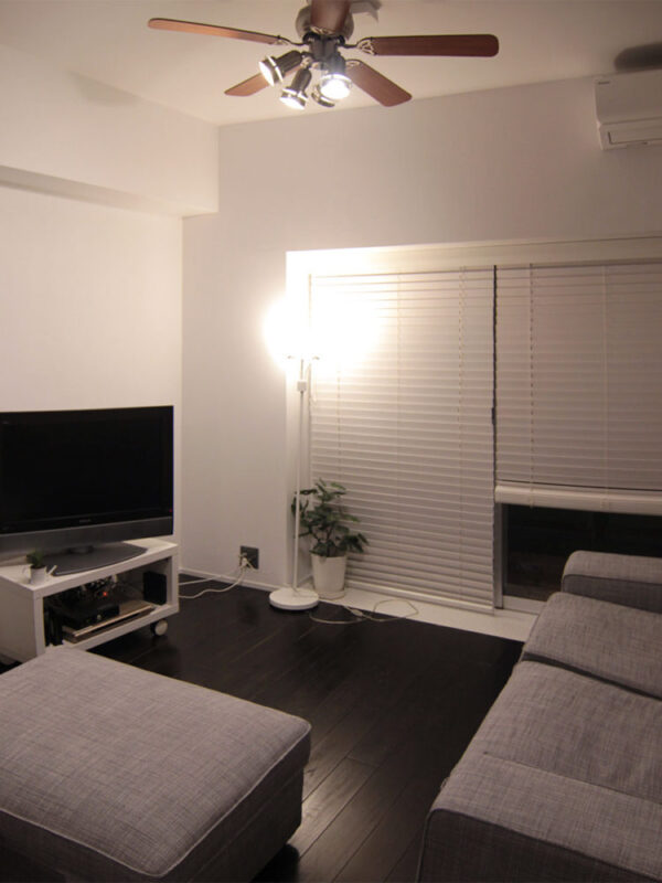 シーリングファンとブラック塗装のオーク無垢フローリングが調和するモダンリビング