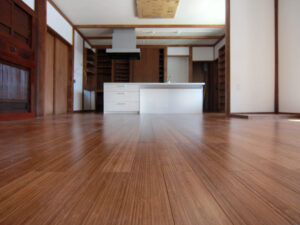 岐阜県恵那市の古民家改築事例。バンブー（孟宗竹）90mm幅縦目積層フローリングを採用し、アイランドキッチンと調和するブラウンの床材