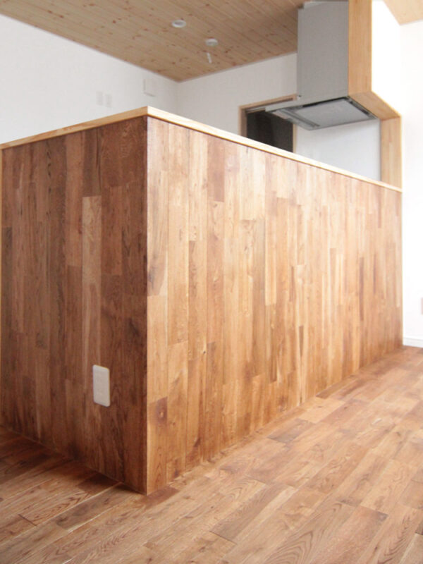 オーク無垢フローリングを壁面に貼ったキッチンカウンターの施工例