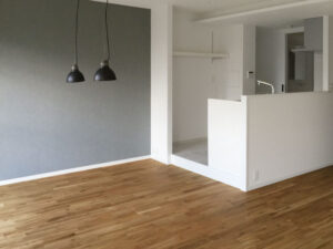 オーク無垢フローリングとモノトーン壁が調和する西宮市のマンションリビング