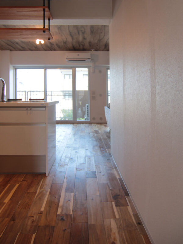 アカシア無垢フローリングが続く廊下からリビングを見た景色