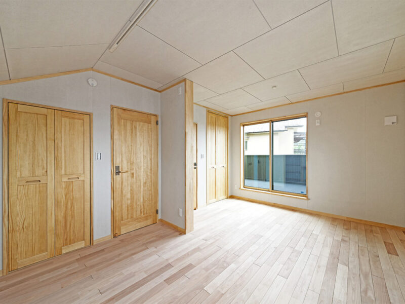 大きな窓と収納扉が並ぶ部屋に敷かれたシルバーチェリー無垢フローリング