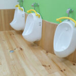 無垢フローリングと木製腰壁を組み合わせた園児用小便器スペース