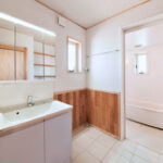 洗面脱衣所の腰壁に施工されたシルバーチェリー無垢フローリング材