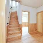 シルバーチェリー無垢フローリングが施工された交野市新築一戸建ての階段とホール