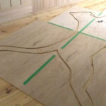 合板に動物のシルエットを描き抜き型を作成する作業工程