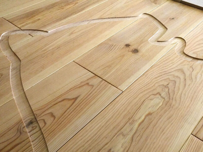 無垢フローリングに埋め込まれた動物シルエットの加工途中