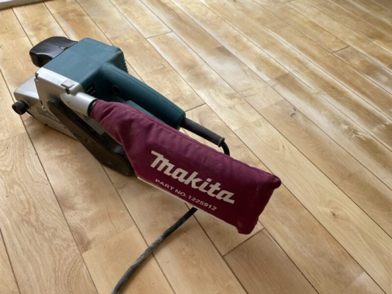 Makitaのベルトサンダーで床を研磨する様子