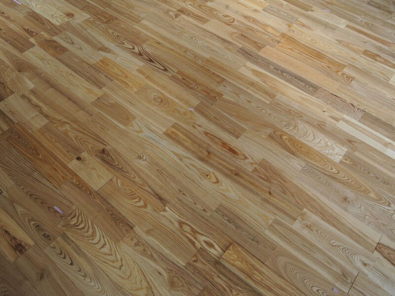 木目の濃淡が美しいアッシュ（タモ）ラスティックグレードの無垢フローリングのクローズアップ