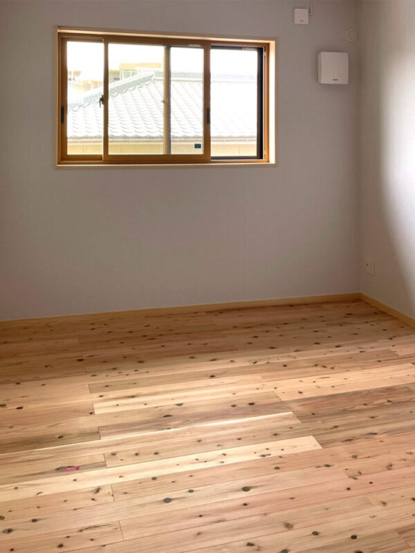吉野杉無垢フローリングを採用した新築一戸建ての洋室と窓からの景観