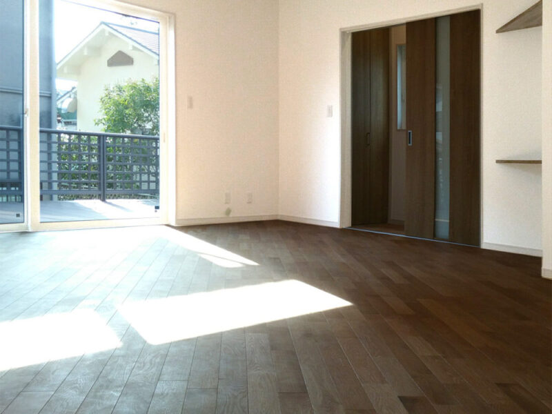 大きな窓から光が差し込むリビングに施工されたオーク無垢フローリング（ヴィンテージブラウン仕上げ）