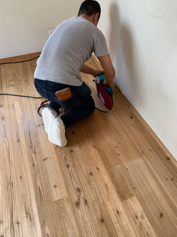 無垢フローリングを研磨する職人の作業風景