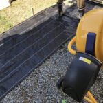 ウッドデッキ施工で防草シートを敷設する作業員