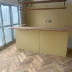 カウンターとアカシア ヘリンボーン無垢フローリングが調和するリノベーション空間