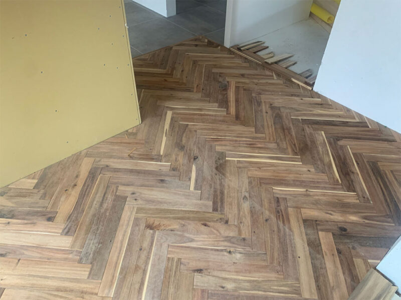 部屋の出入口に広がるアカシア ヘリンボーン無垢フローリング施工