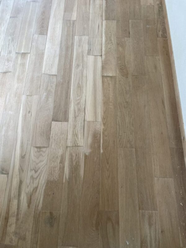 研磨によって半分が白木に戻ったオーク無垢フローリングの比較画像