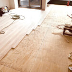 窓際からシルバーチェリー無垢フローリングを施工する様子