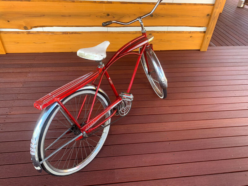 セランガンバツウッドデッキの上に置かれた赤いクラシック自転車