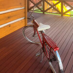 木製の壁面と調和する赤褐色のセランガンバツデッキと自転車