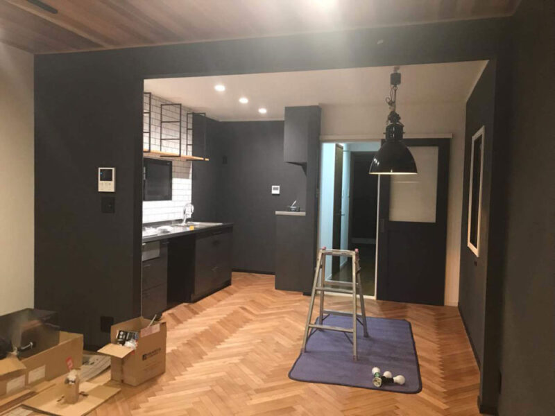 ヘリンボーンフローリングと黒を基調としたキッチン空間