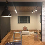 照明とヘリンボーンフローリングのある施工中の空間