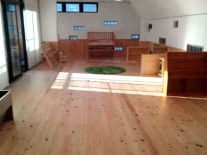 圧密加工を施したヒノキ無垢フローリングの施工直後の床面。光を受けて木目が美しく際立つ。