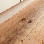 壁際のレッドパイン床材の劣化部分