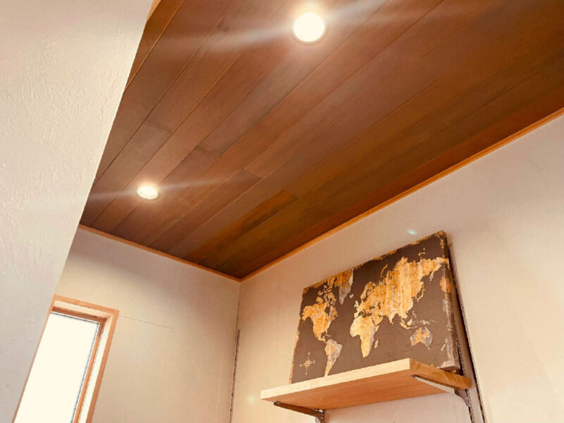 酸化鉄仕上げを施したアガチス無垢羽目板の天井施工例（スポットライト演出）