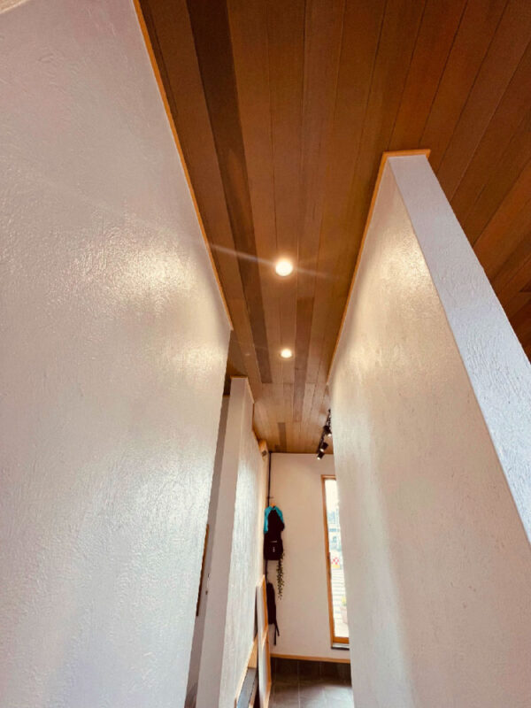 廊下天井に施工された酸化鉄仕上げのアガチス無垢羽目板