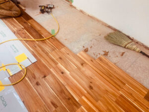 アカシア無垢フローリングの施工途中。大工が釘打ち作業をしている。