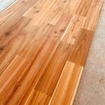 施工中のアカシア無垢フローリングを近接撮影。自然な色合いと節が見える。