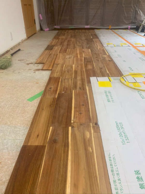 アカシア無垢フローリングを貼り始めた様子。自然な色味の板が並んでいる。