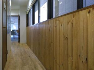 木の温もりが感じられるノルディックパイン羽目板の廊下施工例（神戸市オフィス）