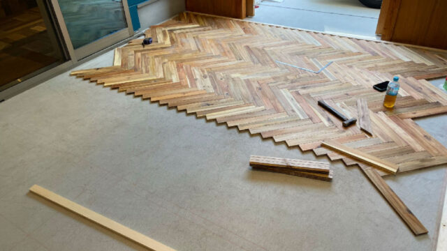 アカシア無垢フローリングを直貼りでヘリンボーン施工する様子