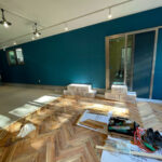 青い壁と無垢フローリング施工中の店舗