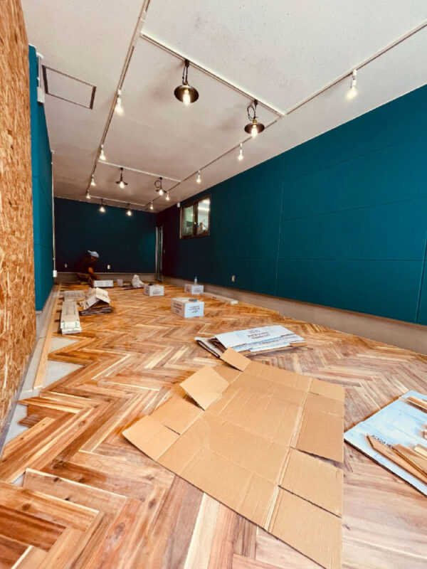 アカシアヘリンボーン無垢フローリングを施工中の店舗全景