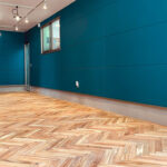 完成したアカシアヘリンボーン無垢フローリングと青い壁