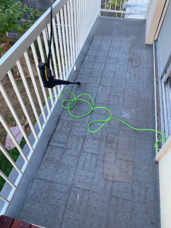 バルコニーの防水面を高圧洗浄前に確認している様子