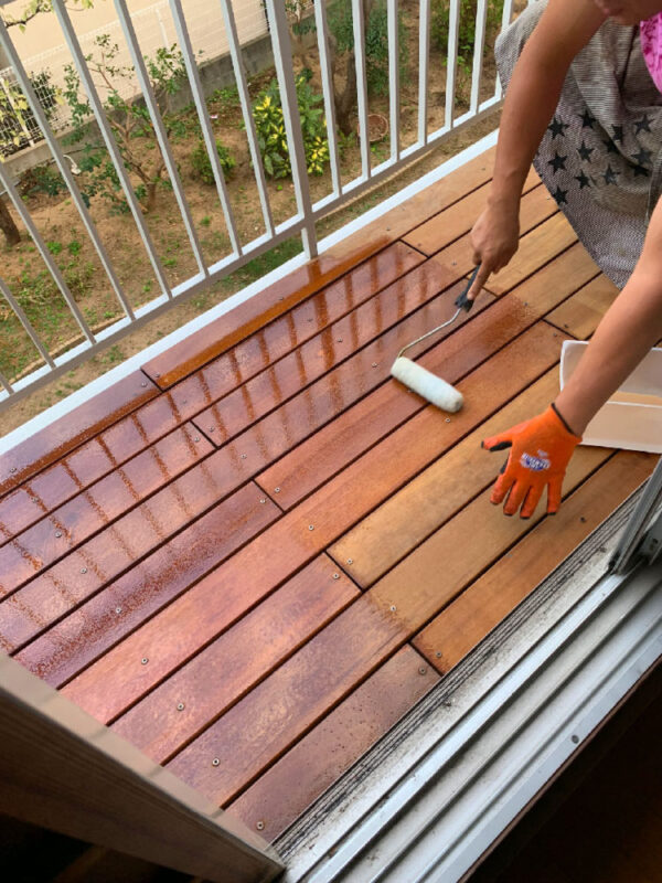 セランガンバツ材に防腐塗料をローラーで塗布している様子