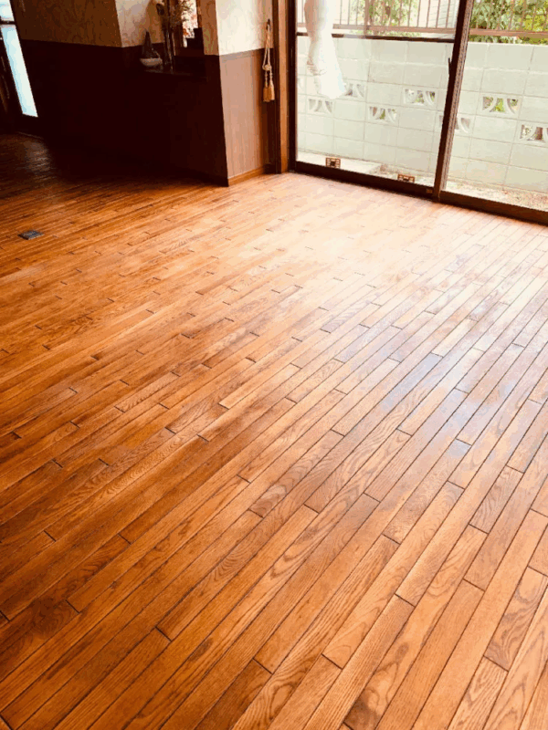 窓際で光を反射するオーク無垢フローリングの表面