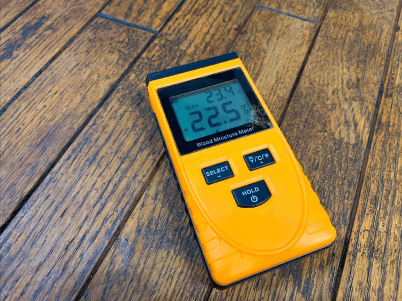 含水率22.5%を示す木材水分計と無垢フローリング
