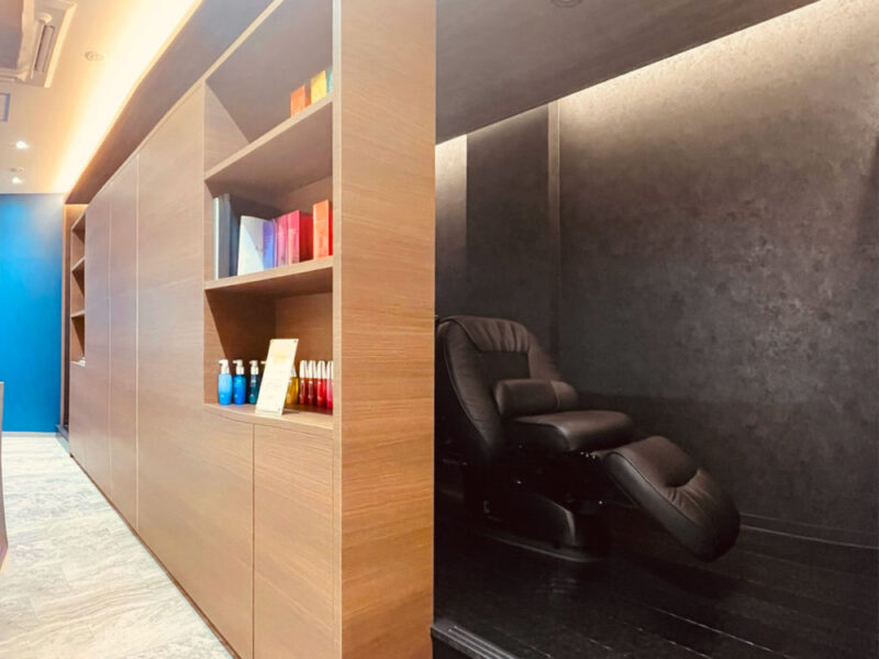 木目調の壁面収納と黒いシャンプーブースのコントラスト
