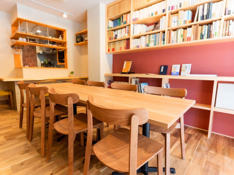 大きなテーブルと木製チェアが並ぶ哲学カフェ懐徳堂の中央席