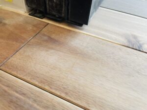 施工前のアカシア無垢フローリング。表面に多数の小傷や凹みが見られる状態。