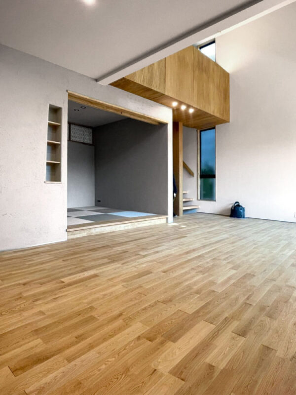 吹き抜けのあるリビングに広がるオーク無垢フローリング。