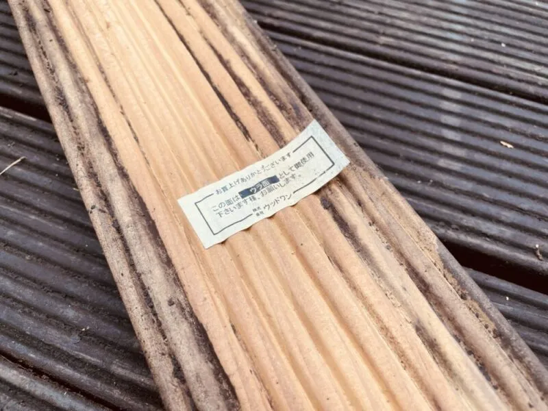 ウッドデッキ材の断面と品質表示ラベルのクローズアップ。