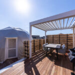 ドーム型テント横のバーベキューエリアと木製デッキ