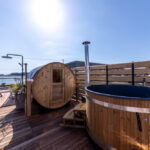 木製サウナと浴槽が並ぶアウトドアスパ空間